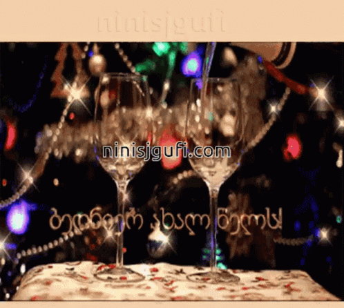 two wine glasses sitting on a table with festive lights and text