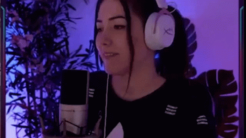 a girl in headphones is holding a microphone