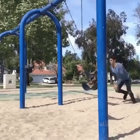 two s play in the park under a wooden swing