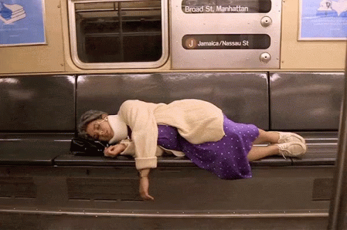 a woman is sleeping on the side of a train