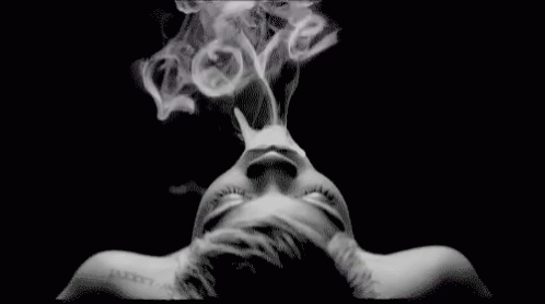 a person with their face down, covered in smoke