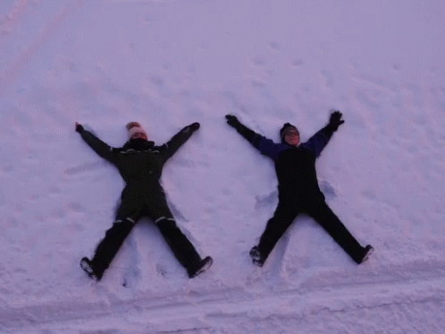 two people in ski gear lying in the snow