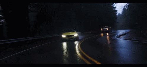 a green car driving on the road at night