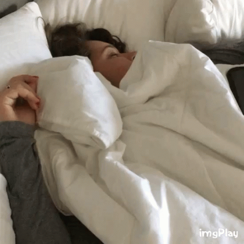 a person sleeping in an overstuffed bed