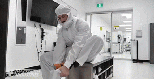 a man in protective clothing is sitting on a box