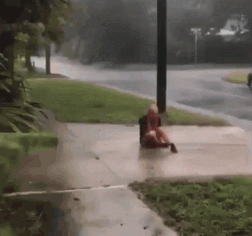 a person is sitting on a cement ground in the street