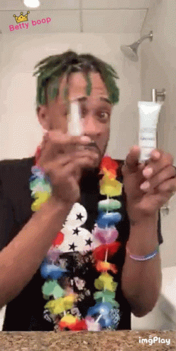 a man is brushing his teeth and holding an empty tube