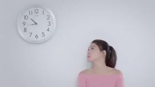 a person is standing under a clock on the wall