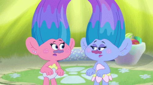 two pinkish animated babies stand in front of some round objects