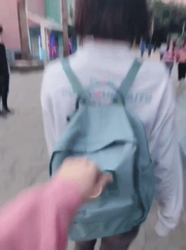 blurry po of a girl carrying a school bag in the street