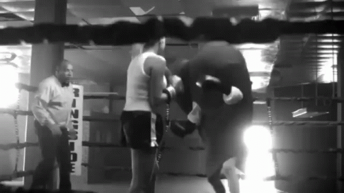 a group of people in a gym holding boxing gloves