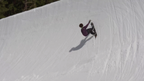 a person riding a snowboard down the side of a hill