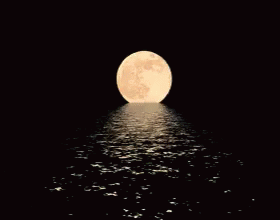 a blue full moon rising above the ocean