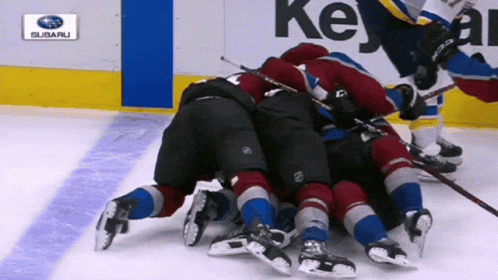 the hockey players are fighting for control of the puck