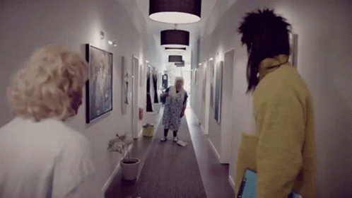 three women walking down the hallway of an apartment