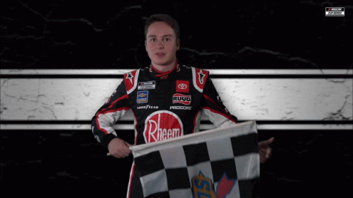 a man holding a checkered flag standing next to his car