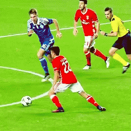 three soccer players trying to block a ball