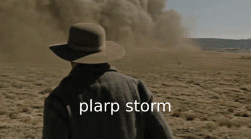 man in a hat looking at a big dust cloud