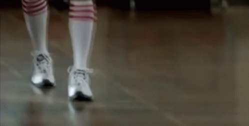 a dancer in socks and sneakers performing on the stage