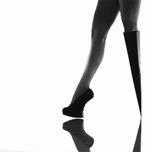 a woman wearing high heels with her legs bent up