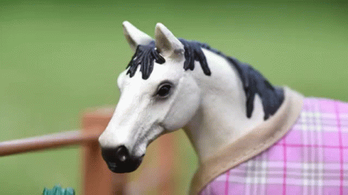 a toy horse dressed in clothing with flower