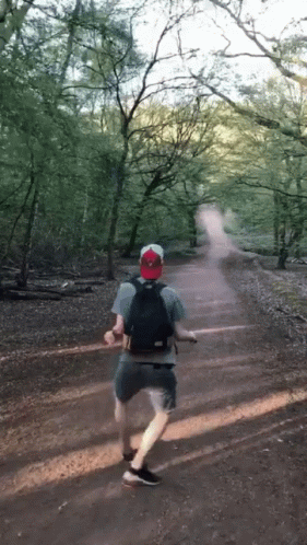 a man running in the middle of a forest