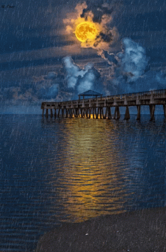 a long bridge extending out over the ocean under a cloudy sky
