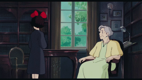 an older woman standing in a room in front of an old man