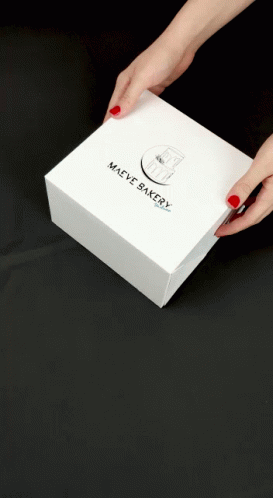 a woman's blue hands holding up a white box
