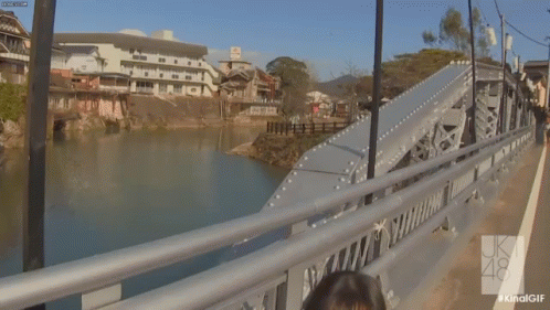 people walking over a bridge with lots of water