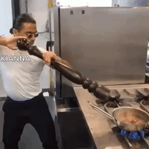 man is preparing food using a metal pot