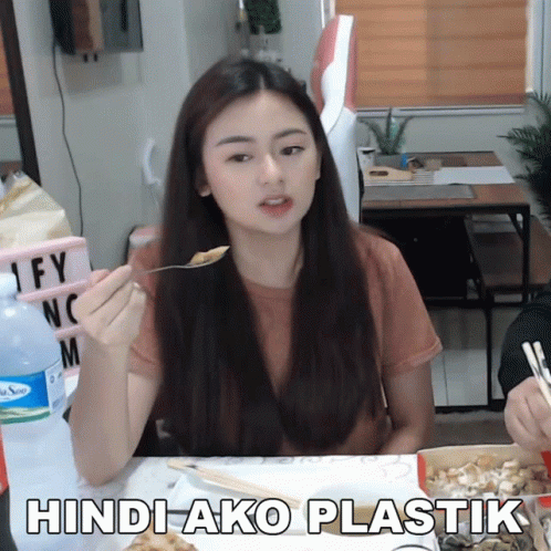 a woman eating food with spoon and fork with an caption saying hindi ako plastick