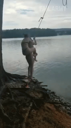 a person holds onto a fishing pole next to the water