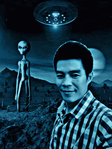 a man standing in front of a alien like object with his hands folded out