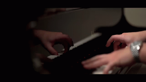 a person with dark hands playing the piano