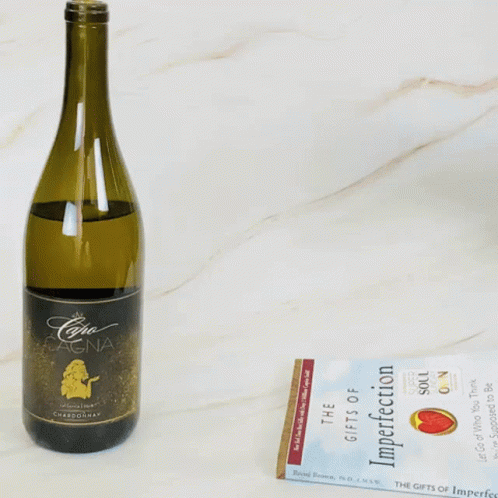 an opened bottle of wine, on a table next to a ticket