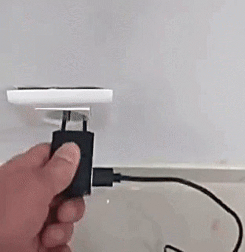 a person plugging electrical cords into the wall