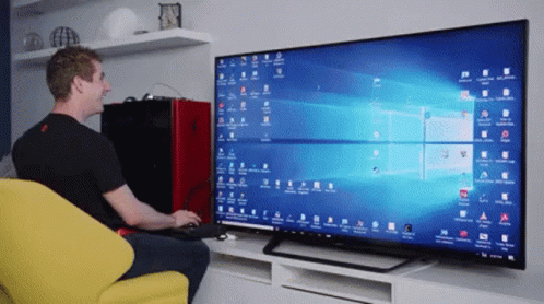 a man sits in front of a flat screen tv