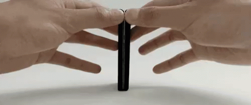 two hands are putting their fingers on the back of a thin phone