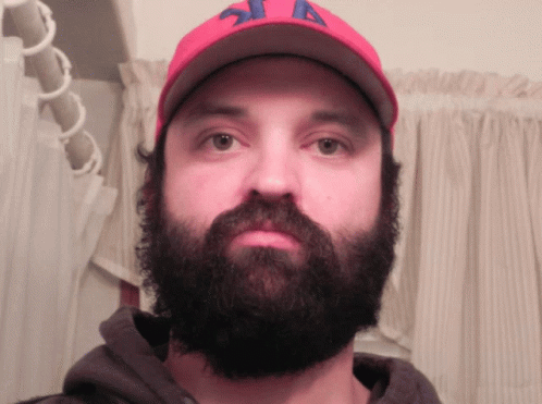 a man with a beard and a baseball cap