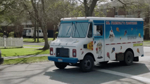 an ice cream truck driving down a snowy street