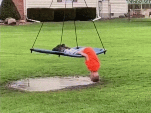a woman is lying on the ground next to a swing