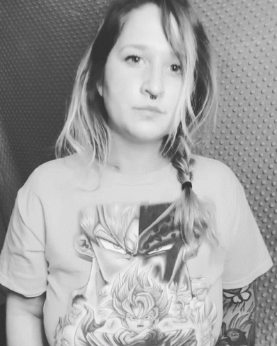 a woman looking into the camera and a shirt with tattoos on it