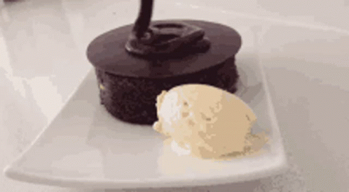 the chocolate cake is decorated with a black icing cone