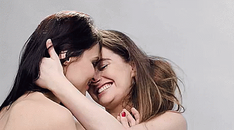 two girls hug each other while smiling