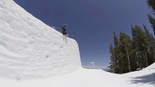 a person is skiing on a half pipe in the snow