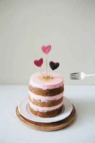 two heart shaped sticks sticking out of a layered cake
