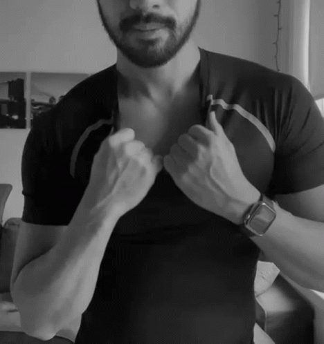 a man is adjusting his clothes in a black shirt