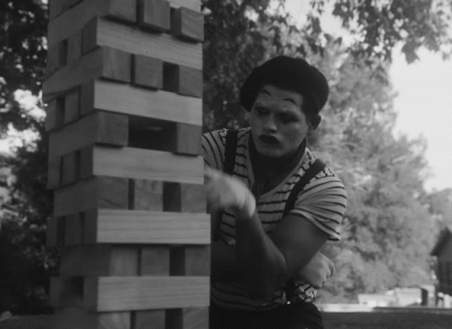 a woman leaning on a wall made out of wooden blocks