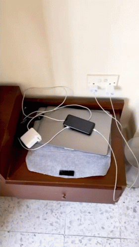 an electronic device charging on top of a drawer